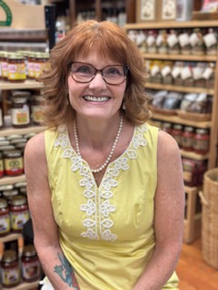 Tonya Johnson Peach, smiling in a yellow embroidered top and pearl necklace